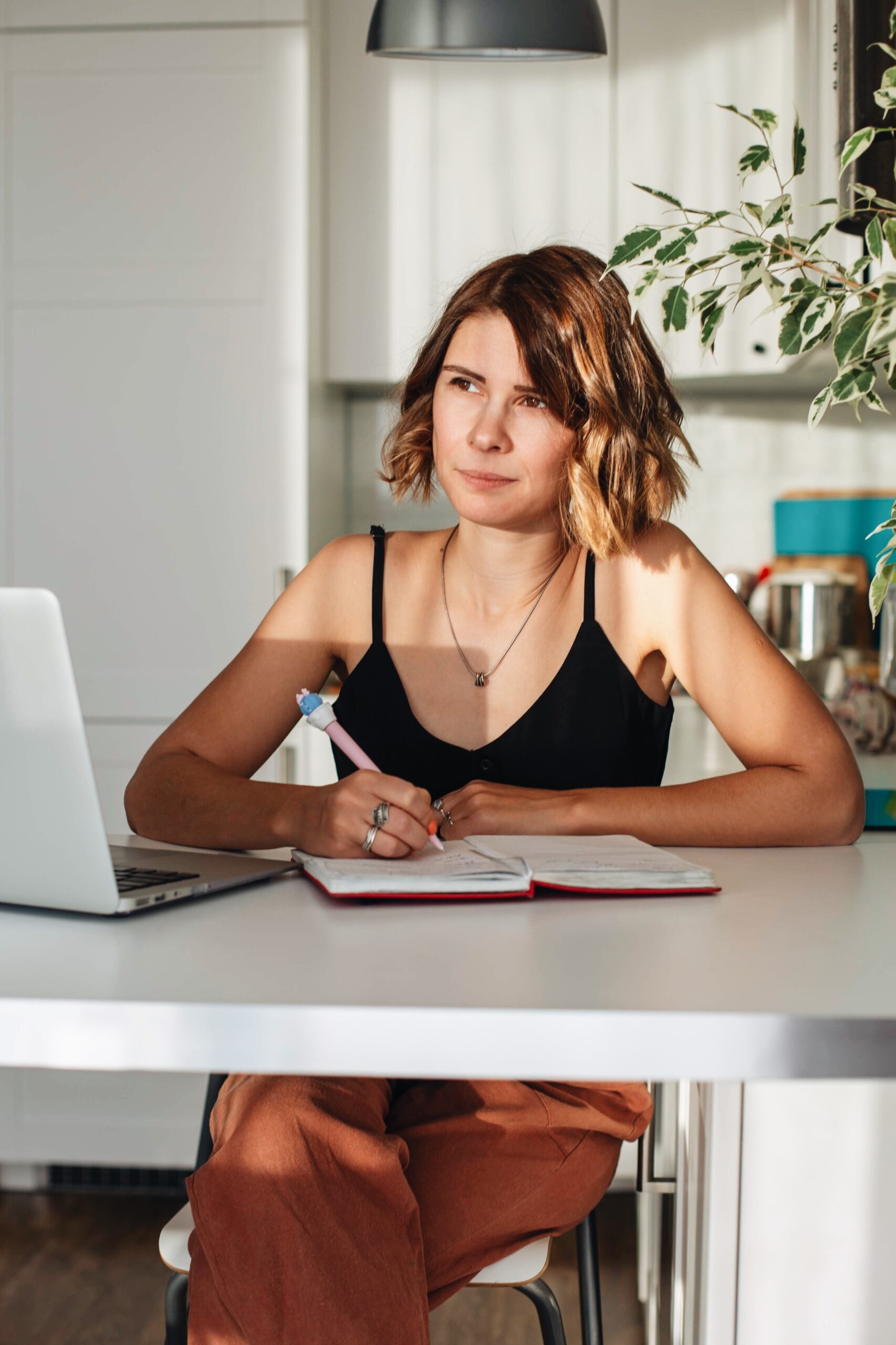 A lady writing down the factors influencing the transition of a struggling trader to a consistently profitable trader